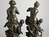 two bronze statues of a man and a woman on a rock