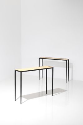deux tables dans une pièce aux murs blancs et au sol blanc