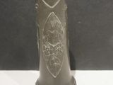 a black vase with a design on it sitting on a table