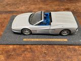 une maquette de voiture de sport argentée posée sur une table