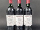 three bottles of red wine sitting on top of a table