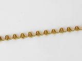 a close up of a gold chain with bells on it