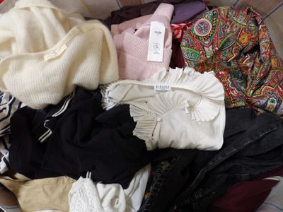 a pile of clothes sitting in a basket on the floor