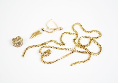 a pair of scissors and a gold chain on a white surface
