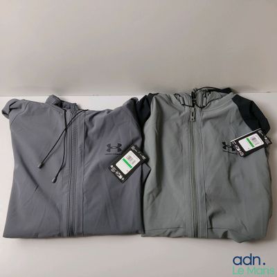 two jackets with tags on them sitting next to each other