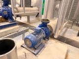 a blue and white pump in a room with pipes