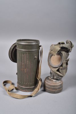 une paire de vieux masques à gaz et une cartouche sur fond blanc