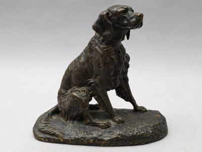 statue en bronze représentant un chien et un chat assis sur un rocher