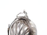 a silver purse sitting on top of a white table