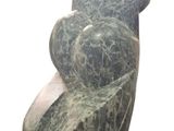 a stone sculpture of a woman sitting on a chair