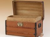 un petit ours en peluche assis dans une vieille valise
