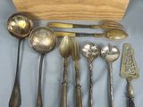 Plusieurs cuillères et fourchettes sont disposées sur une table