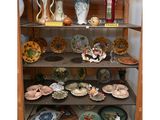 de nombreuses assiettes et vases sur les étagères de ce buffet