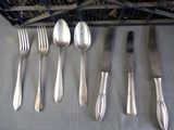 a lot of silver spoons and forks on the table