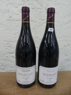 deux bouteilles de vin posées sur une table l'une à côté de l'autre