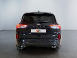 the back end of a black suv parked in a room