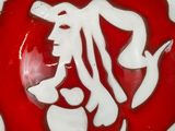 a red and white plate with a picture of a man on it