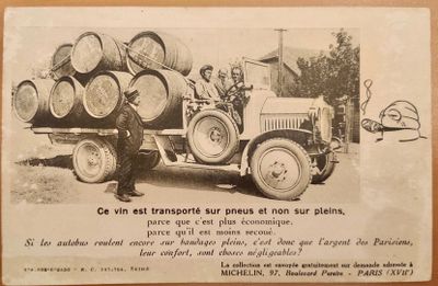une vieille photo d'un homme debout à côté d'un camion sur la benne duquel sont empilés des fûts