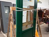 une palette en bois sur laquelle repose une porte verte dans un entrepôt