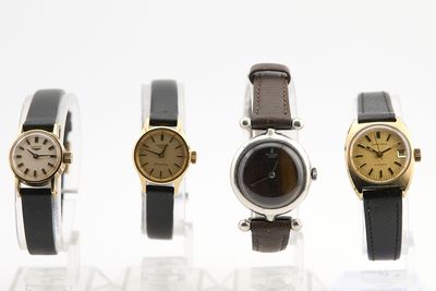 trois montres différentes exposées en rangée sur une surface blanche