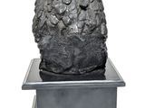 sculpture of a pine cone on a metal stand on a white background