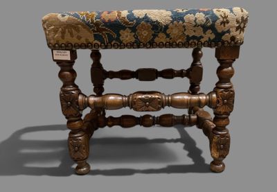 a small wooden stool with a blue and gold upholstered seat