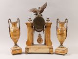 three vases and a clock sitting on a table