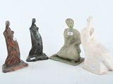 trois figurines représentant une femme et un homme assis sur une surface blanche