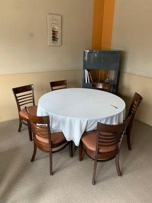 une table et des chaises blanches dans une pièce avec une cheminée