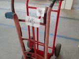 a red hand truck with a price tag on it in a warehouse