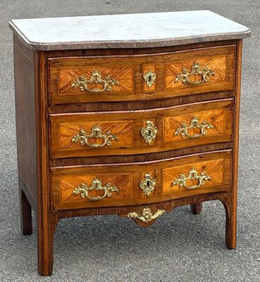 une commode au plateau en marbre, abandonnée dans la rue