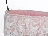 a pink and white basket hanging from a wire