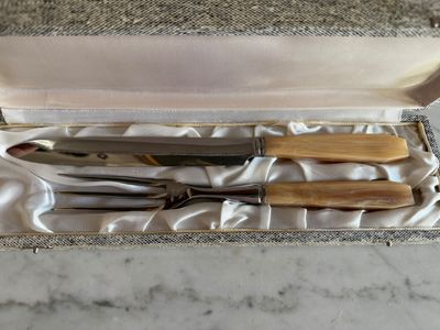 quatre couteaux dans une boîte posée sur un plan de travail en marbre