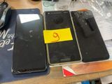 trois téléphones portables posés sur une table, sur lesquels est collé un autocollant jaune