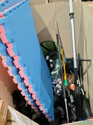 un tapis bleu et rose dans une boîte, à côté d'un parapluie bleu
