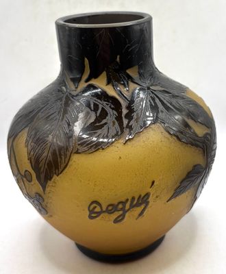 a yellow vase with a black design on it