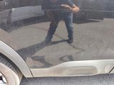 a man standing in front of a car with his reflection in the door