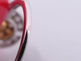 a silver ring with a red heart inside of it