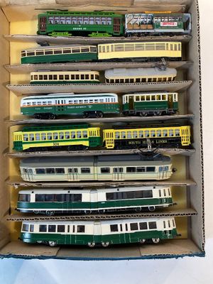 plein de petits trains miniatures dans une boîte posée sur la table