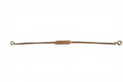 un bracelet en or avec une barre suspendue à une chaîne