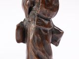 bronze statue of a woman holding a book on a wooden base