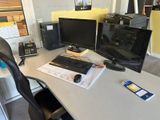 a computer desk with two monitors and a keyboard on it
