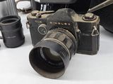a black camera with a silver lens on a white table