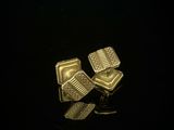 pair of gold plated cufflinks on a black surface