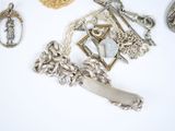a lot of silver jewelry on a white surface