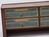 a small chest of drawers with a wooden top