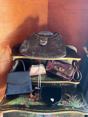 several purses are stacked on top of each other on a table