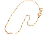 a close up of a gold chain with a diamond on it