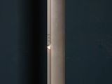 the floor lamp is standing on the concrete floor next to the wall
