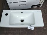 a white sink sitting next to a cardboard box